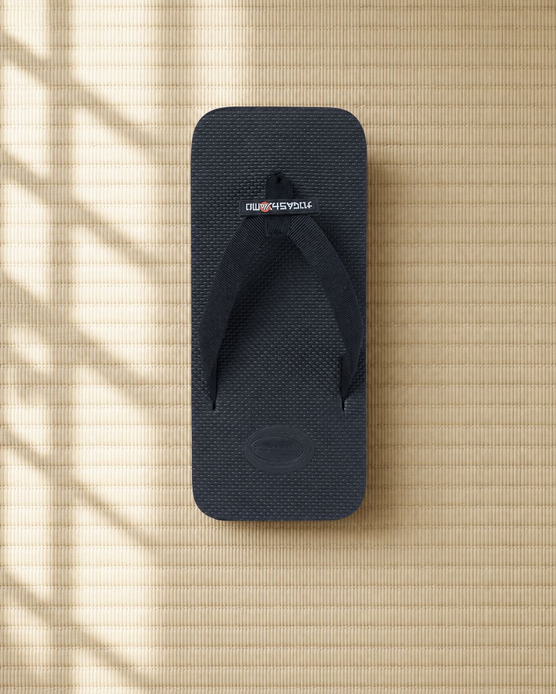 From above — the full footbed on tatami: proportion, thong placement and the moulded logo panel